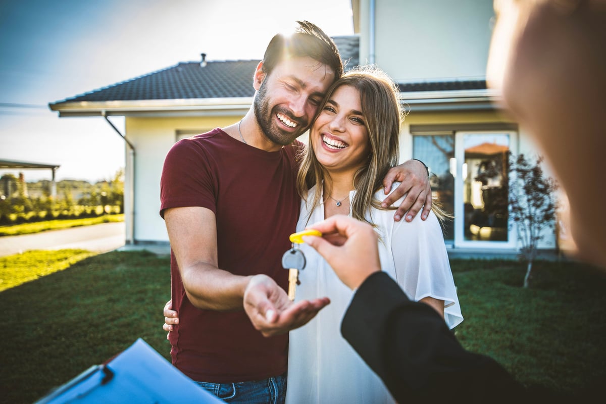 Couple receiving the keys to their first home from their real estate agent