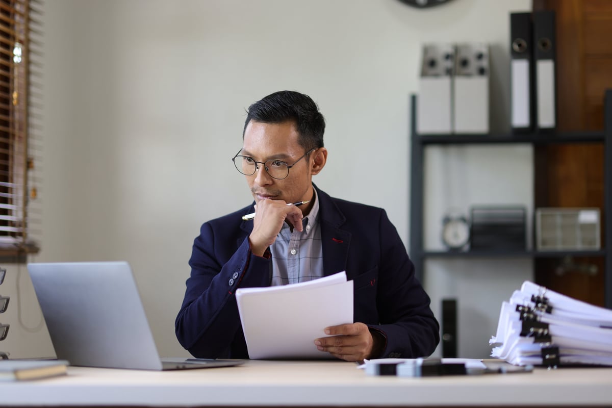 Executive reviewing business paperwork at a desk