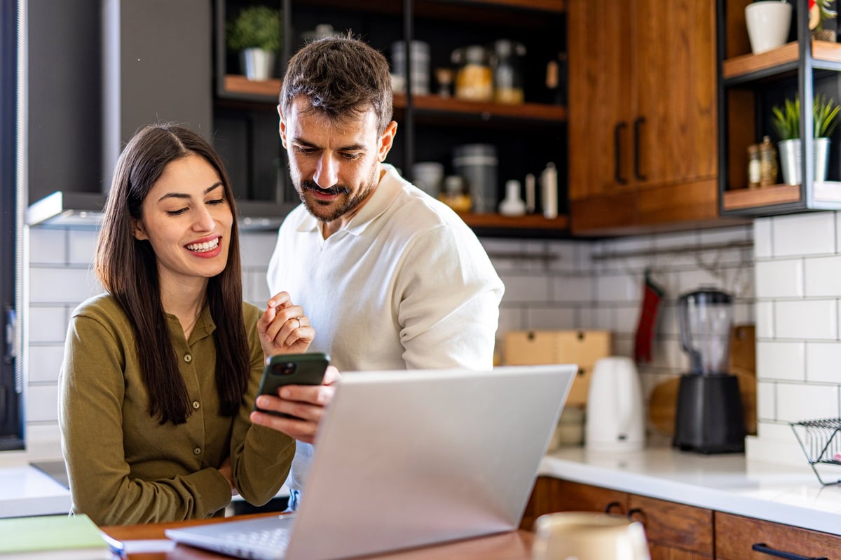 Couple managing their household finances online at home