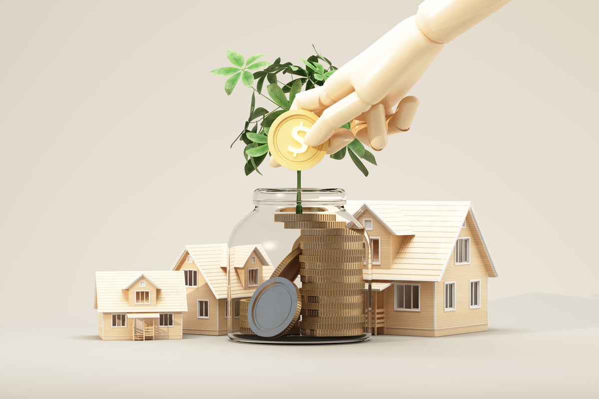 Wooden houses and a growing plant from a coin jar illustrating financial growth and sustainable property planning.