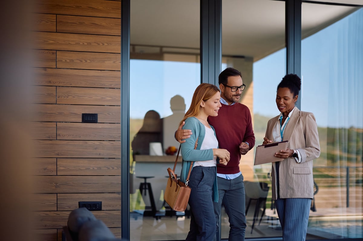 African American real estate agent going through housing plans with a couple who is buying a new home.