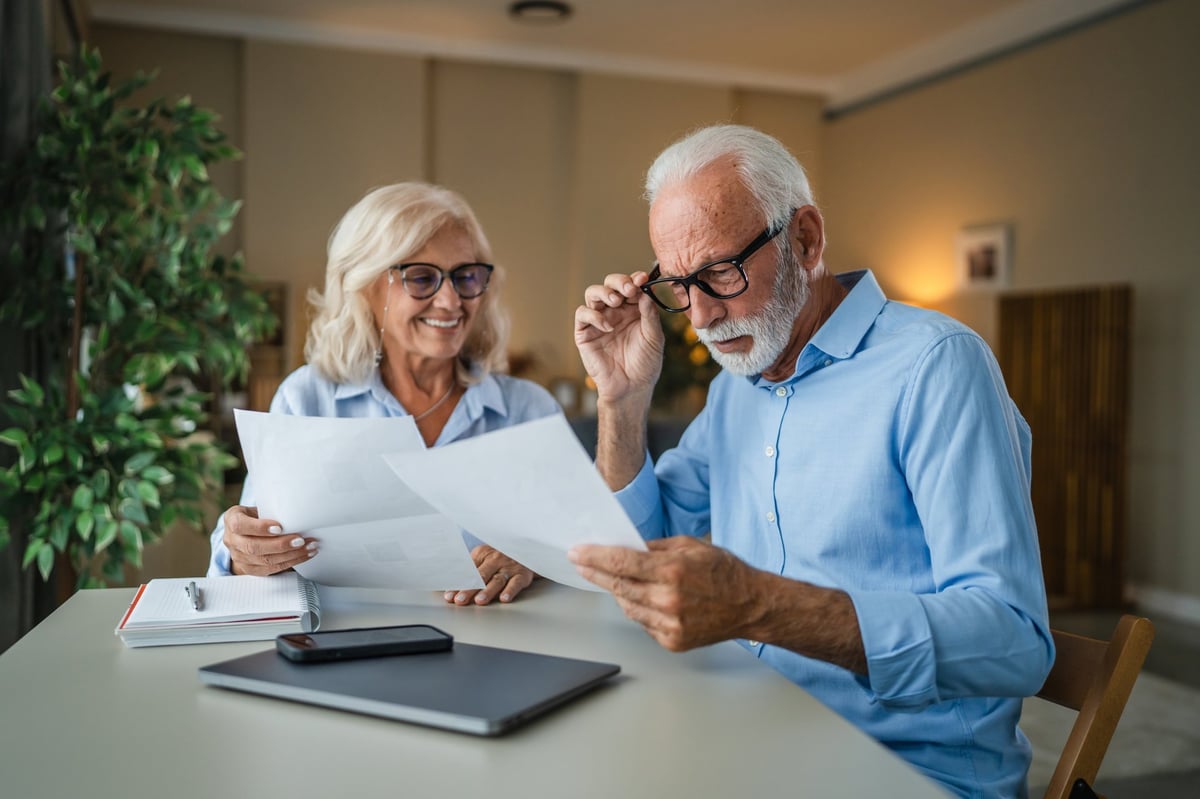 Senior couple at home reviewing investment and savings paperwork together