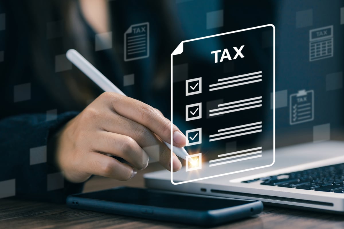 Hand using stylus with glowing digital tax checklist, representing tax filing, financial planning, accounting, auditing, and compliance in modern business management.