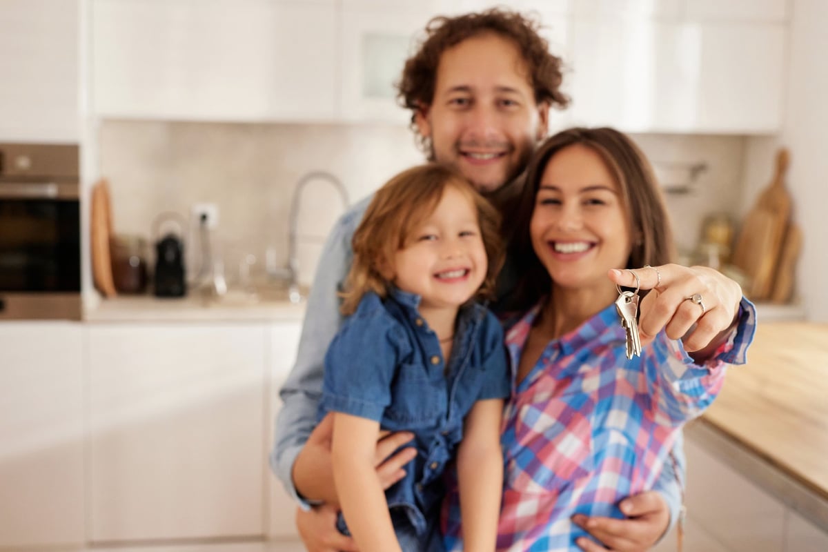 Smiling family celebrating moving into their new house, showcasing success and homeownership