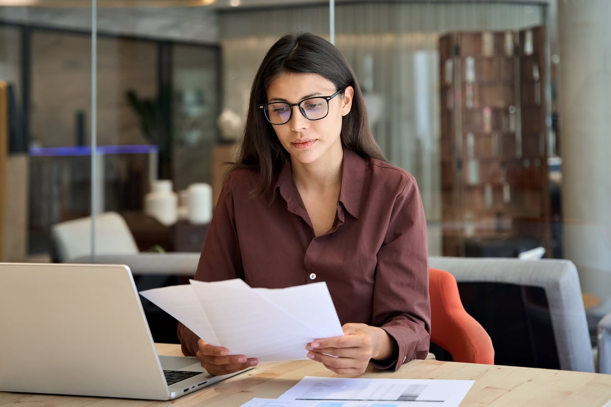 Business owner reviewing financial reports at a desk in an upscale office