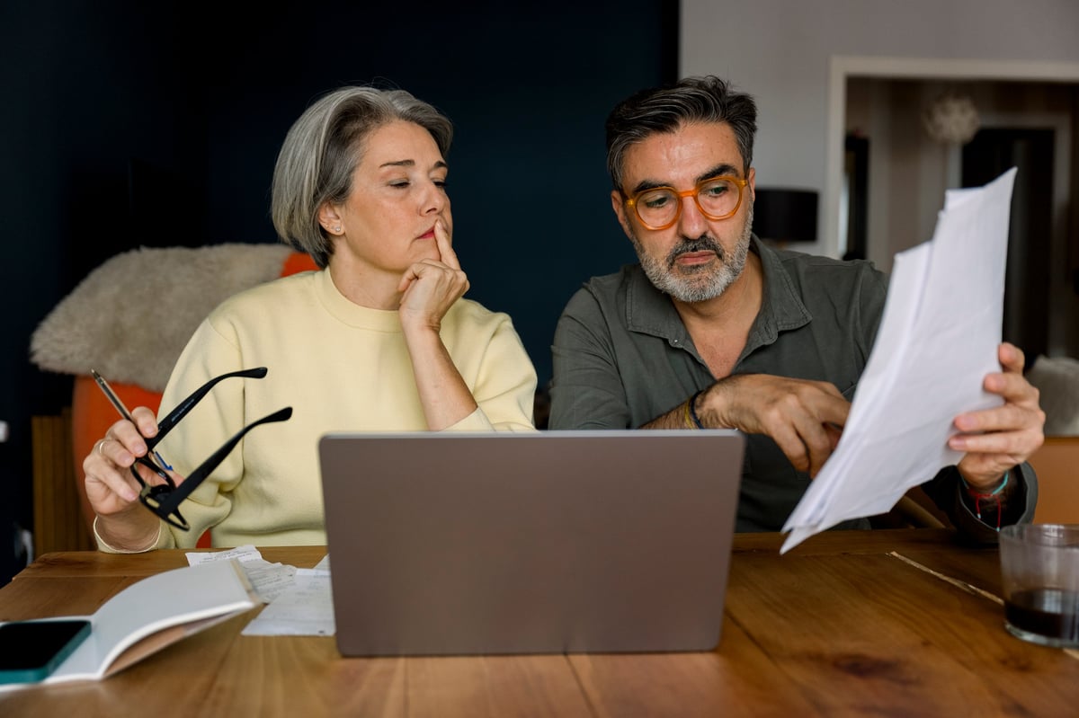 Couple reviewing mortgage payment documents at a home desk