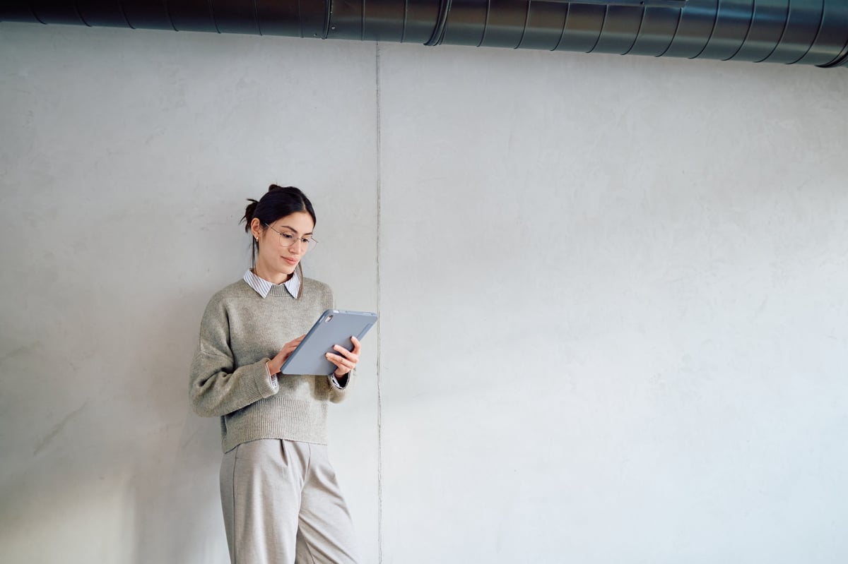 Woman focusing on digital tablet, managing her business