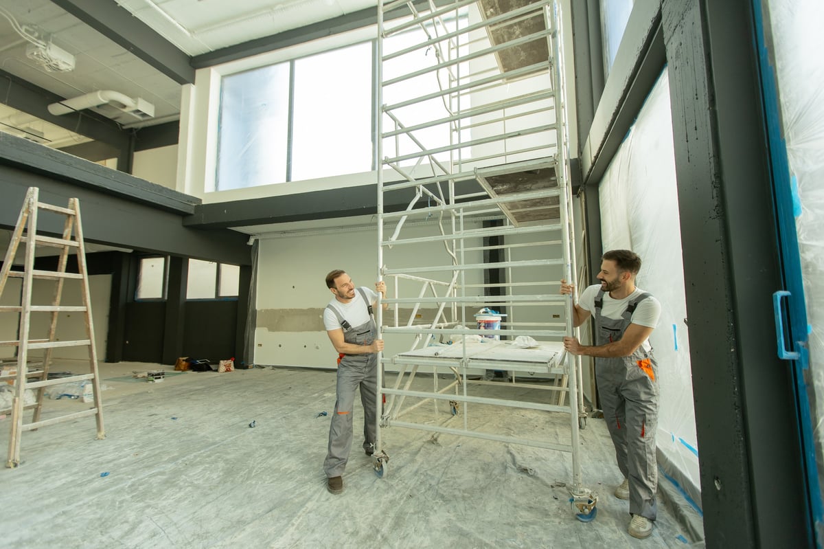 Workers painting and renovating a modern interior with scaffolding