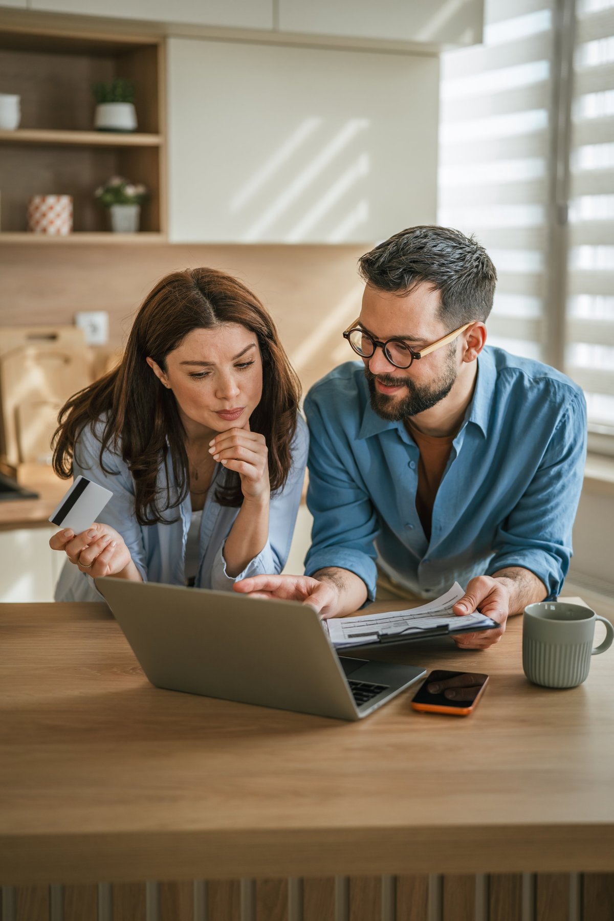 Couple reviewing a long-term household budget at their kitchen counter