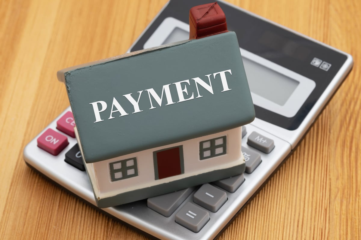 Payment text on a house on a calculator on a desk for mortgage, insurance and property taxes