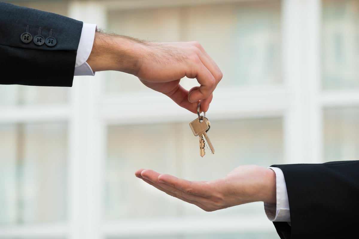 Real estate agent handing house keys to an international buyer
