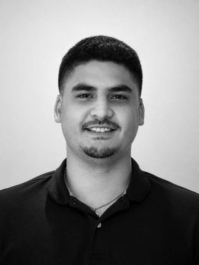 Black and white professional headshot of a smiling man wearing a dark polo shirt against a plain background