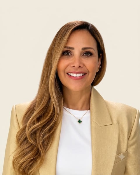 Professional headshot of a smiling woman with long brown hair wearing a beige blazer and white top